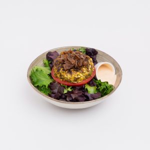 Hambúrguer de lentilhas e arroz integral, com topping de cebola caramelizada, maionese de sriracha caseira, servido com uma base de mistura de alfaces.